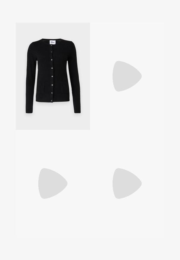Sort cardigan med knapper, lange ærmer og lommer. Modellen sidder på en stol med en tekstureret pude i baggrunden.; Sort ribbet t-shirt med rund halsudskæring og trekvart ærmer. Stoffet har en glat tekstur og lige kant. Ingen synlig branding.; Blå denim jeans med lige ben, der har en let falmning, fem lommer og en enkelt knaplukning i taljen.; Sort læder peep-toe slingback sko med høj blokhæl og beige indvendig foring mod en ensfarvet lys baggrund.