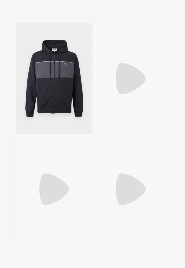 Sweat à capuche zippé noir et gris foncé avec capuche à cordon de serrage et logo crocodile vert Lacoste sur la poitrine.; T-shirt noir à manches courtes avec col rond et logo embossé "Lacoste Paris" sur la poitrine, sur un fond uni.; Pantalon de jogging bleu marine avec taille élastique et poignets aux chevilles, arborant un logo discret en patch sur la cuisse supérieure.; Baskets basses blanches Lacoste avec lacets, logo embossé sur le côté et semelle texturée sur fond uni.