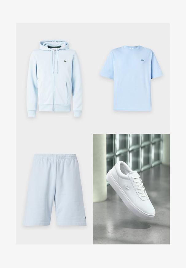 Sudadera con cremallera de color azul claro en una mezcla de algodón, con un bolsillo tipo canguro, puños acanalados y un pequeño logo verde en la zona del lado izquierdo del pecho.; Camiseta de algodón de color azul claro con cuello redondo, mangas cortas y un pequeño logotipo bordado en la parte izquierda del pecho. Textura suave, corte relajado.; Pantalones cortos de algodón azul claro con cinturilla elástica. Presenta un diseño simple y sólido con dobladillo abierto. Acento del logo en el dobladillo inferior.; Zapatilla blanca de caña baja con diseño de cordones y logo de cocodrilo en relieve, situada sobre un suelo pulido gris con una pared de bloques de vidrio de fondo.
