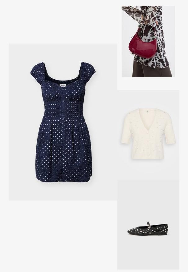 Kurzärmlige V-Ausschnitt-Cardigan in Cremefarbe, aus weichem Material gefertigt, mit dekorativen Perlen- und Strassverzierungen sowie Knopfverschluss.; Marineblaues kurzes Kleid mit weißen Polka-Dots, Knopfleiste vorne, geraffter Taille und Rüschen an den kurzen Ärmeln.; Schwarze Leder-Ballerinas mit spitzem Fuß, verziert mit silbernen Nieten und einem seitlichen Schnallenriemen. Strukturierte Oberfläche mit flacher Sohle.; Frau trägt eine schwarz-weiß gemusterte Bluse und hält eine glänzende rote Schultertasche vor einem einfarbigen Hintergrund.