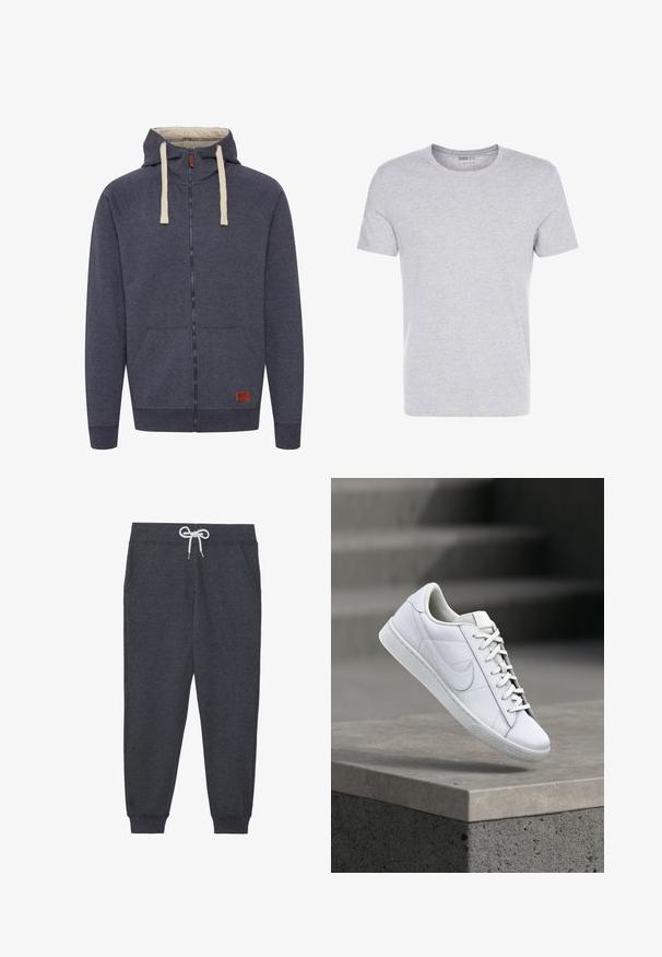 Heren hooded zip-up sweatshirt in donkergrijs fleece. Kenmerken zijn crèmekleurige trekkoorden, voorzakken en een klein bruin leren logo-patch.; Grijze katoenen t-shirt met een ronde hals, korte mouwen en een eenvoudige uitstraling, met een zachte, gladde textuur en zonder zichtbare patronen of versieringen.; Donkergrijze sweatpants van zacht materiaal, met een elastische tailleband en witte trekkoord, voortassen en geribbelde manchetten.; Witte lederen sneaker met veters en Nike swoosh-logo die boven een betonnen richel zweeft in een buitenomgeving.