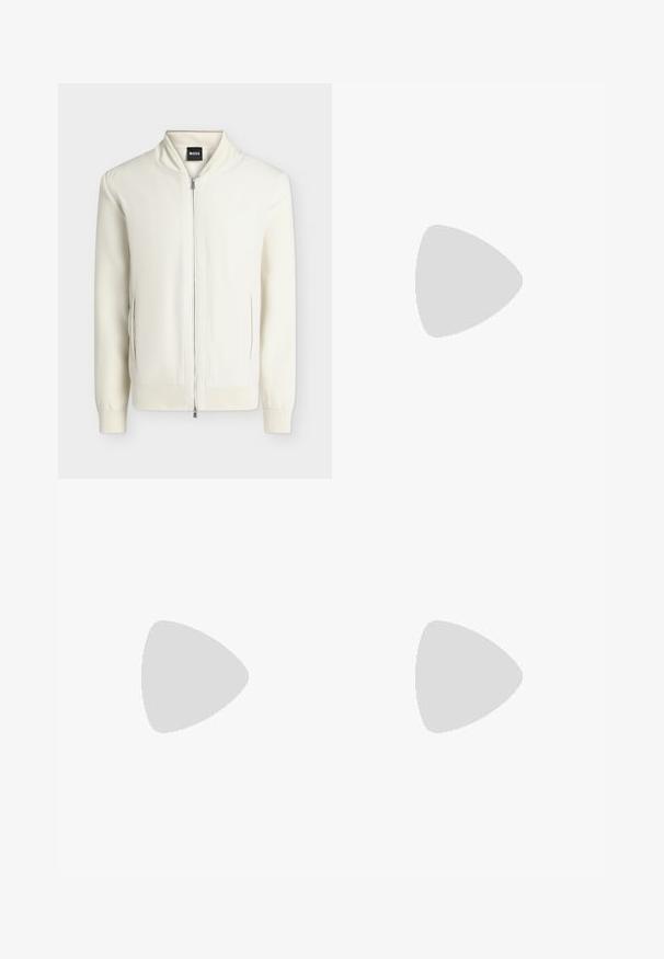 Veste bomber blanche zippée avec col, poignets et bas côtelés, deux poches latérales et une étiquette BOSS à l'intérieur du col.; Chemise crème à manches longues avec boutons, col boutonné et petit logo brodé sur la poitrine gauche.; Pantalon slim vert foncé ajusté avec passants de ceinture et fermeture avant dissimulée, présenté sur un fond clair.; Chaussure habillée en cuir noir poli avec lacets, flottant au-dessus d'un tapis beige, avec une table ronde orange-brun brillante en arrière-plan.