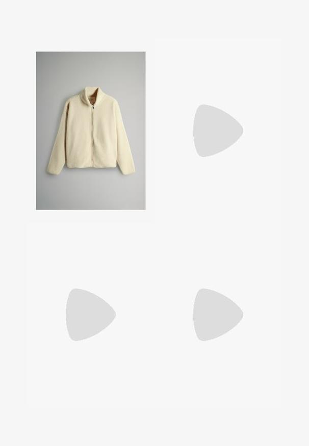 Crème-kleurige fleece jacket met een hoge kraag, een volledige ritssluiting aan de voorkant en een verlengde schouderlijn. Zachte textuur, relaxte pasvorm en geen zichtbare patronen.; Beige shirt met lange mouwen en ronde hals, losvallende pasvorm en zachte stof, plat gelegd op een witte achtergrond.; Beige elastische broeken met een tailleband, twee voorzakken, taps toelopende pijpen en een gladde textuur, geschikt voor casual kleding.; Witte sneakers met een glad leren bovenwerk, een gestructureerde rubberen zool, lichtroze accenten op de hiel en platte veters. Gummilogo-embleem aan de zijkant.