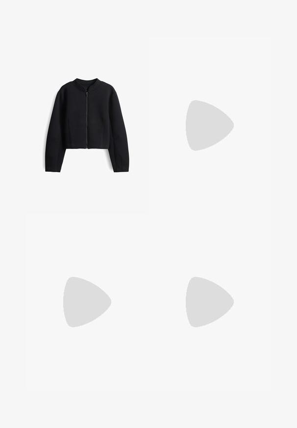 Veste noire raccourcie en tissu lisse. Équipée d'un col haut et d'une fermeture éclair à l'avant. Comprend des détails de coutures discrets sur les manches.; T-shirt en coton gris à manches courtes, col rond et coutures blanches contrastées le long des coutures et des ourlets. Design simple et sans embellissement.; Pantalon noir à jambes larges en tissu doux, avec une taille haute, des plis à l'avant, sans éléments métalliques visibles ni motifs.; Baskets montantes en toile noire avec semelle en caoutchouc blanche et lacets blancs, vues de côté sur un fond blanc.