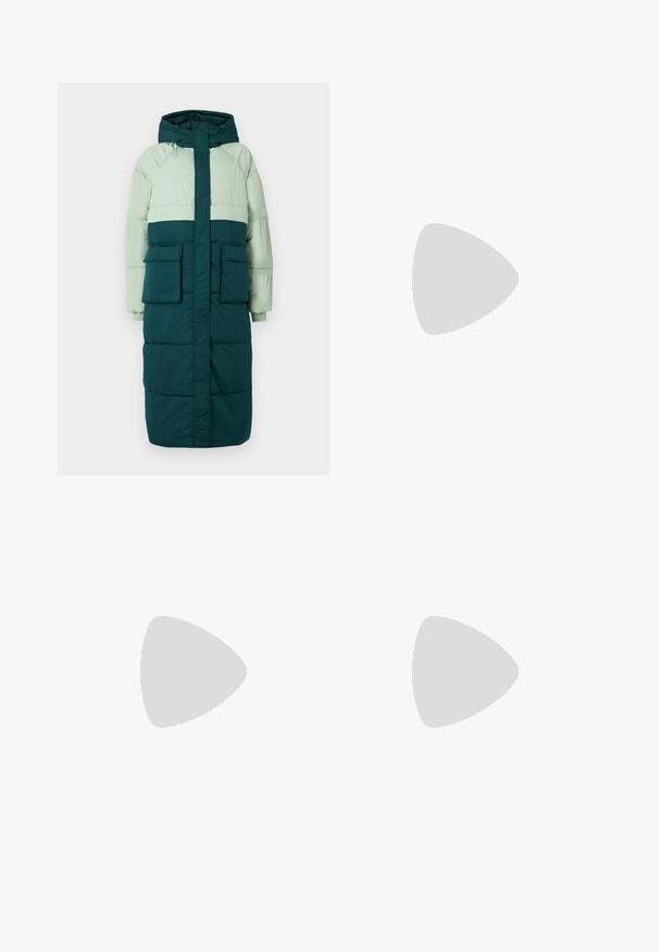 Puffjakke med hætte, har et farveblokeringsdesign i lys grøn og mørk teal, to frontlommer og ribbede manchetter.; Lyseblå sweater lavet af blød, tekstureret stof, med rund hals, lange ærmer og ribbede manchetter og kant.; Lyseblå, højtaljede, vidde bukser med bølget teksturmønster, foran knapper, lynlås og bæltestropper.; Ben iført mørke ribbede leggings kombineret med sorte balletsko med små sløjfedetaljer på hvid baggrund.