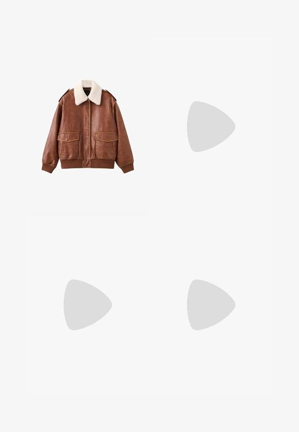Veste aviateur en cuir marron avec un col en fausse fourrure blanche douce, deux poches avant, et des poignets et un ourlet côtelés. Texture lisse avec des coutures visibles.; Haut blanc à manches longues avec un design croisé et une poche. Fabriqué dans un tissu lisse et extensible. Coupé dans une coupe décontractée et ample.; Jean denim bleu clair à jambes larges avec deux poches arrière et une petite étiquette de marque beige sur la ceinture.; Bottines en suede beige avec des accents en cuir marron, des œillets dorés et une semelle texturée. Chaussettes blanches visibles au-dessus des bottines.
