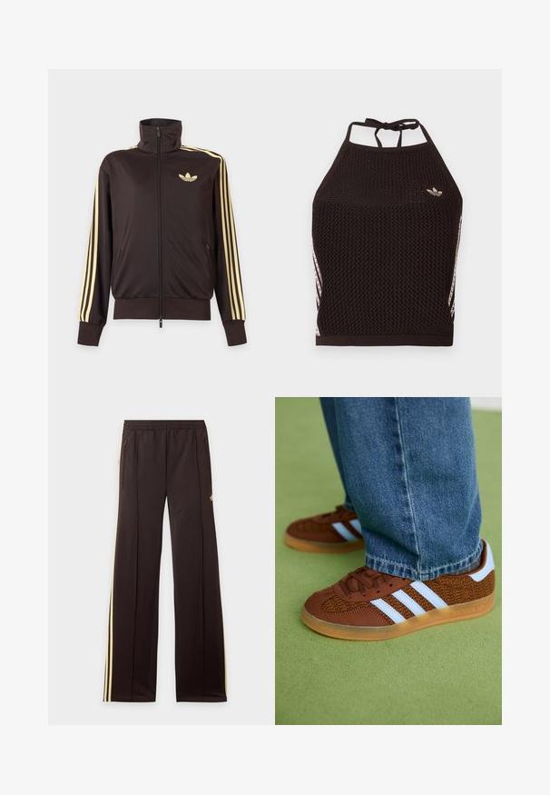 Zwarte joggingjas met rits en hoge kraag, lichtgele strepen op de mouwen en Adidas trefoil-logo op de linkerborst.; Zwarte mesh halter crop top met een textuurpatroon. Voorzien van roze accentstrepen en een klein logo aan de voorkant. Sluiting met strik aan de achterkant.; Zwarte trainingsbroek met gele zijstrepen, elastische tailleband, ritszakken aan de zijkant en een klein logo op het bovenbeen.; Bruine Adidas sneakers met witte strepen en rubberen zolen, gedragen met blauwe jeans op een groene vloer.