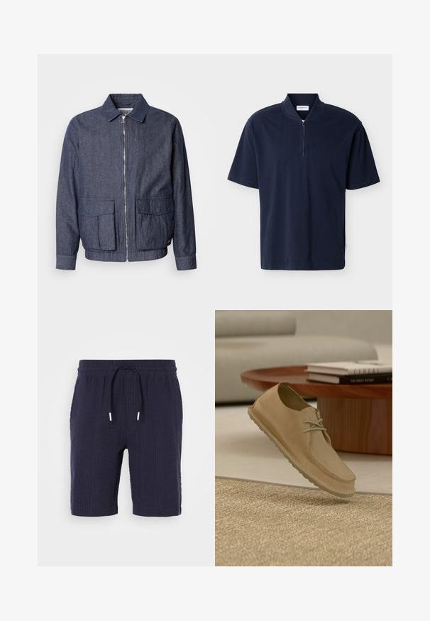 Scotch & Soda BLOUSON - Blouson Bomber - sky captain; Chemise bleu marine à manches courtes avec col montant et fermeture éclair centrée sur fond uni.; Shorts navy avec un motif texturé, taille élastique et cordon de serrage. Présente une coupe décontractée et une longueur au-dessus du genou.; Chaussure décontractée à lacets en daim beige flottant au-dessus d'un tapis texturé dans un salon moderne avec une table basse en bois et des livres.