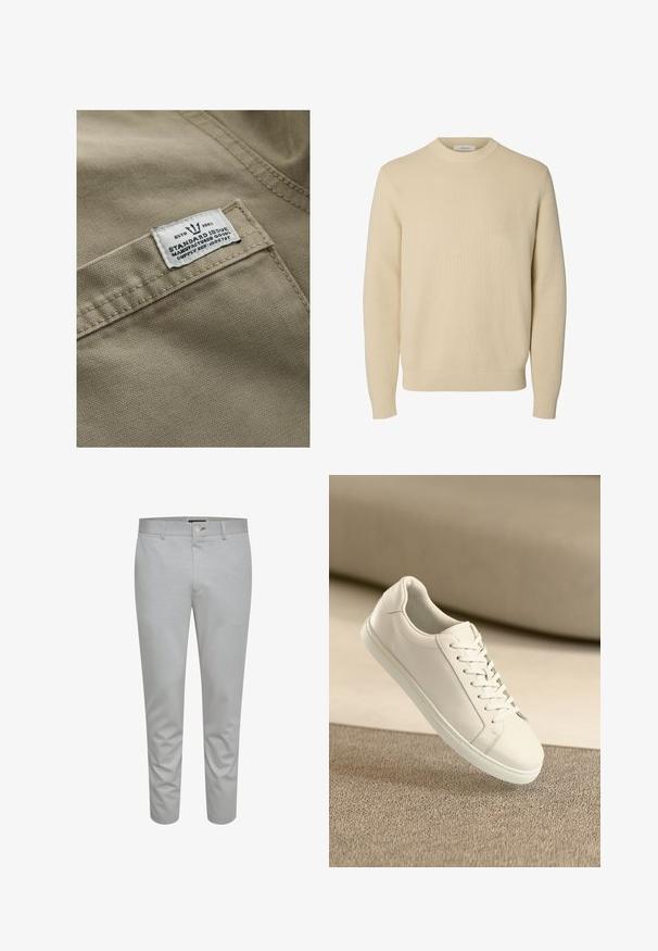 Tejido caqui con una superficie texturizada, con una etiqueta blanca cosida en un bolsillo que incluye el texto "ESTD 1982," "STANDARD ISSUE," y referencia de suministro.; Jersey de punto beige liso con cuello redondo, mangas largas y puños y bajo acanalados.; Pantalones ajustados de color gris claro con una textura suave, que cuentan con un cierre de botón, trabillas para cinturón y bolsillos frontales. Diseño recortado a la altura del tobillo.; Zapatilla de cuero blanca con cordones blancos, exhibida sobre una superficie texturizada beige y un suave fondo desenfocado.