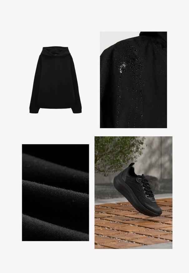 Zwarte stof met waterdruppels die op het oppervlak parelen en naar beneden lopen, wat de waterbestendige eigenschappen benadrukt.; Zwarte hoodie met een relaxte pasvorm, raglanmouwen en ribgebreide manchetten en onderkant. Gladde textuur zonder patronen of zichtbare hardware.; Zwarte stof met een ribbelachtige textuur en subtiele pluizen. De afbeelding toont lagen met gladde randen en een constante kleur door het geheel.; Zwarte sportieve sneaker met dikke zool en veters zwevend boven een houten tegelvloer, wazige buitenachtergrond met groen bladertapijt en muur.