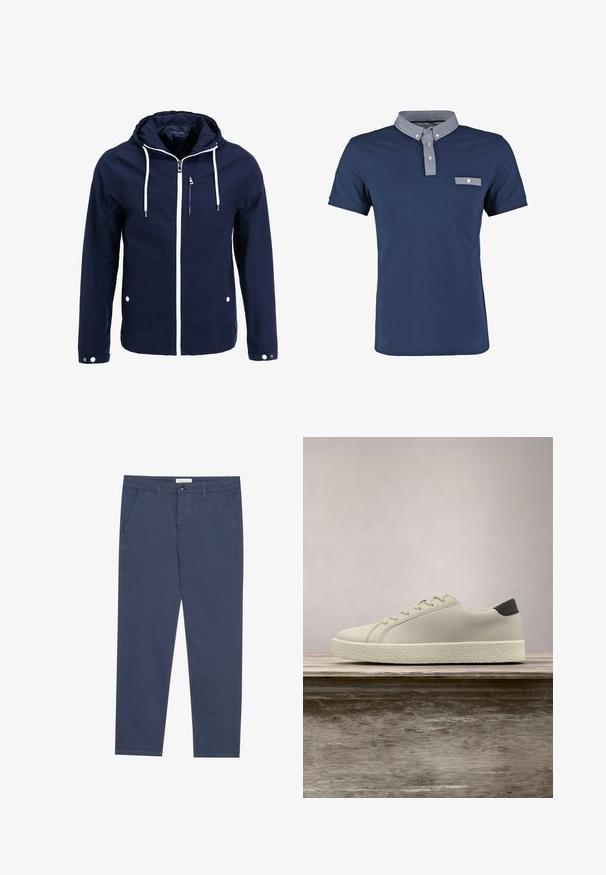 Chaqueta naval impermeable con capucha, cremalleras blancas y cordones. Cuenta con un bolsillo frontal con cremallera y dos bolsillos laterales con snaps. Textura suave.; Polo shirt navy de algodón, con un cuello chambray en contraste, un pequeño bolsillo en el pecho y mangas cortas. Ajuste clásico y textura suave.; Chinos de algodón azul marino con corte recto, dos bolsillos frontales y un sutil detalle de costura, que cuentan con una cinturilla con cierre de botón.; Zapatilla blanca con suela texturizada y detalle negro en el talón, flotando sobre un banco de madera con hierba alta y verde de fondo.