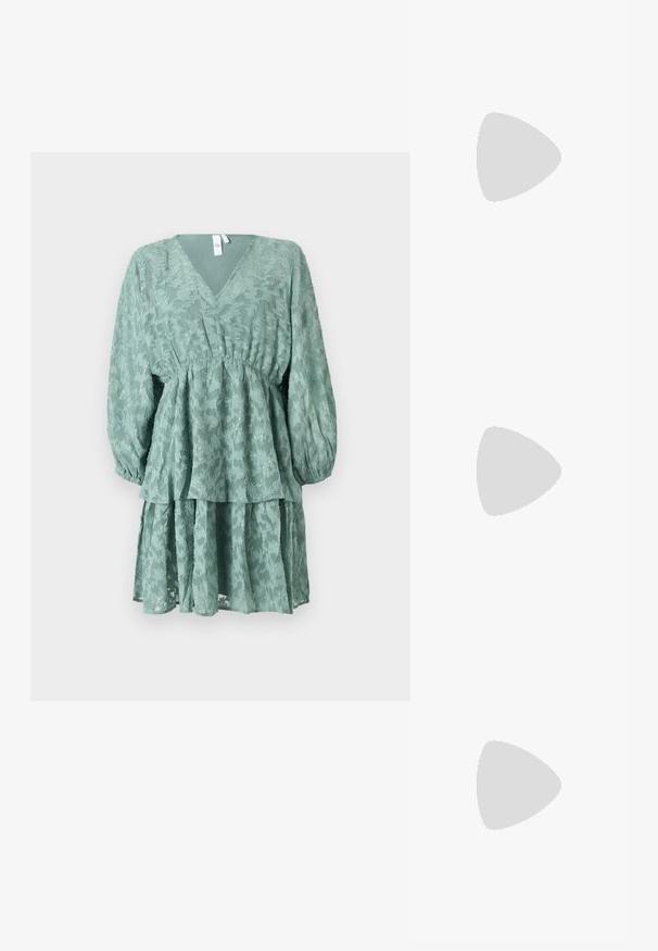 Grünes, schichtweise gestaltetes Kleid mit V-Ausschnitt, langen Puffärmel und floralen Texturen. Verfügt über eine Taillenbetonung und einen fließenden, gestuften Rock.; Schwarzer Leder-Bleistiftrock mit Frontschlitz, kombiniert mit kniehohen schwarzen Stiefeln mit Reißverschlüssen und einer derben Sohle für zusätzlichen Halt.; Kleine schwarze glänzende Handtasche mit zwei langen Griffen und seitlichen Kordelzug-Details vor einfachem hellem Hintergrund.; Pilgrim Ohrringe - gold-coloured