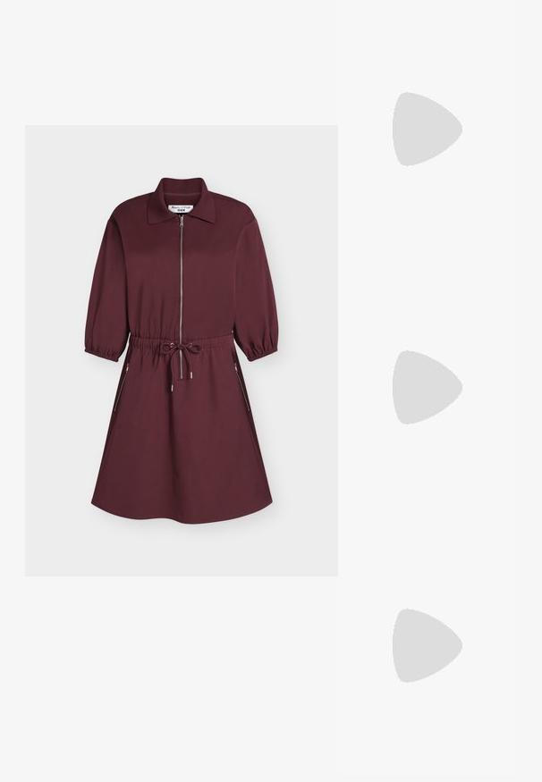 Bordeauxfarbendes knielanges Kleid mit Kragen, Frontreißverschluss, elastischem Bund mit Kordelzug, dreiviertel Ärmeln und seitlichen Reißverschlusstaschen.; Schwarzer knöchelhoher Lederstiefel mit Blockabsatz und dekorativem Riemen mit goldener Schnalle oberhalb des Knöchels, Seitenansicht auf weißem Hintergrund.; Schwarze Leder-Umhängetasche mit zwei Schulterriemen, versehen mit einem floralen Seidenschal, der am Griff gebunden ist, sowie einem metallischen Logoakzent auf der Vorderseite.; Silberne Creolen mit polierter Oberfläche, die kleine goldene Akzentdetails und eine runde Form aufweisen, am Ohrläppchen getragen.