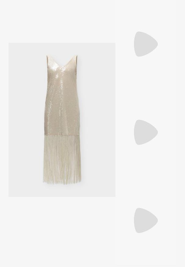 Robe beige sans manches à sequins avec décolleté en V et longues franges à l'ourlet, présentée sur un fond uni.; Sandale à talons hauts dorée avec des lanières, design en T, bandes frontales tressées étroites et un talon fin. Fini métallique lisse et boucle à la cheville.; Pochette matelassée métallisée dorée avec serrure en forme de cœur et chaîne dorée attachée sur fond blanc.; Collier en perles et bracelet assorti avec fermoirs en or et petit charm rond en or décoré de petits cristaux sur fond blanc.