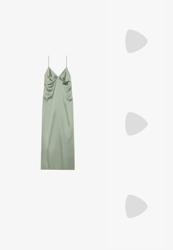Robe en satin vert avec des bretelles spaghetti réglables, présentant un détail de nœud au centre et un tissu drapé pour un ajustement fluide.; Tongs avec une semelle texturée beige, de fines brides brunes et des accents en paillettes dorées. Design léger adapté à une utilisation décontractée.; Sac seau en paille tissée avec une base large, un sommet étroit et une bandoulière en cuir marron ajustable.; Paire de petites boucles d'oreilles créoles en or avec des pendentifs en forme de cœur gravés de la lettre "C" sur un fond blanc.