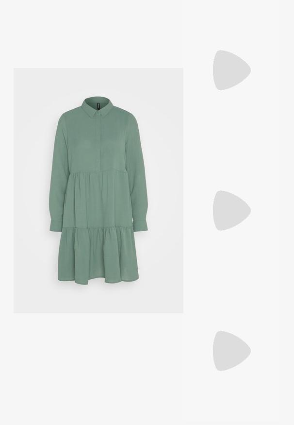 Vero Moda VMINGE KNEE DRESS - Blousejurk - dark forest; Witte leren cowboylaars met een spitse neus en een vierkante hak. Heeft ingewikkelde stikpatronen op de schacht en een soepele textuur.; Cat-eye zonnebril met een zwart en oranje schildpadframe, bruine lenzen en slanke, puntige uiteinden. Bevat een minimalistisch logo op de poot.; Gouden ring met twee verweven banden; de bovenkant is gepolijst en reflecterend, terwijl de onderkant een matte afwerking heeft.