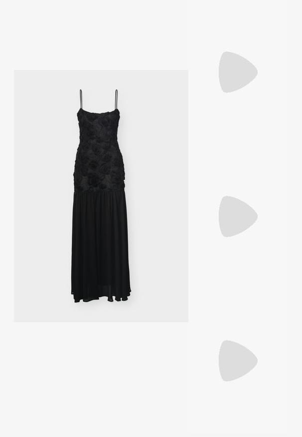 Robe noire longue jusqu'au sol avec fines bretelles, corsage texturé à motifs floraux et jupe fluide en chiffon.; Bottine en cuir noire mi-mollet avec un petit talon carré, bout pointu et une sangle décorative à la cheville avec une boucle en argent sur fond uni.; Sac à main en cuir noir de forme arrondie, décoré de clous argentés et équipé d'une poignée courte. Texture lisse et fermeture éclair.; Boucles d’oreilles créoles en métal argenté avec une surface lisse légèrement incurvée et des fermoirs à clapet sur un fond blanc uni.