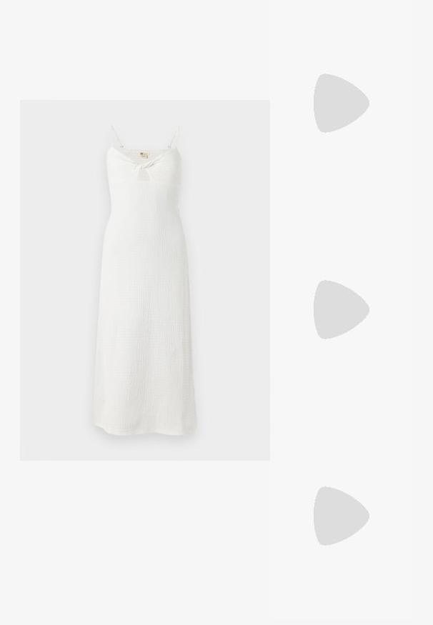 Vestido blanco sin mangas con un detalle de nudo en la parte delantera. Hecho de una tela texturizada, tiene un corsé ajustado y una falda fluida hasta los tobillos.; Sandalias planas negras con tiras trenzadas y un acento metálico. Presentan una hebilla ajustable y una suela de goma plana para mayor comodidad.; Bolso de mano de paja trenzada con textura natural, acentuado por un ribete y asa de hombro de cuero sintético negro; diseño de apertura en la parte superior.; Pendientes de aro en tono plateado con forma redonda y un acabado pulido. Ambos pendientes son del mismo tamaño y cuentan con un mecanismo de cierre seguro.