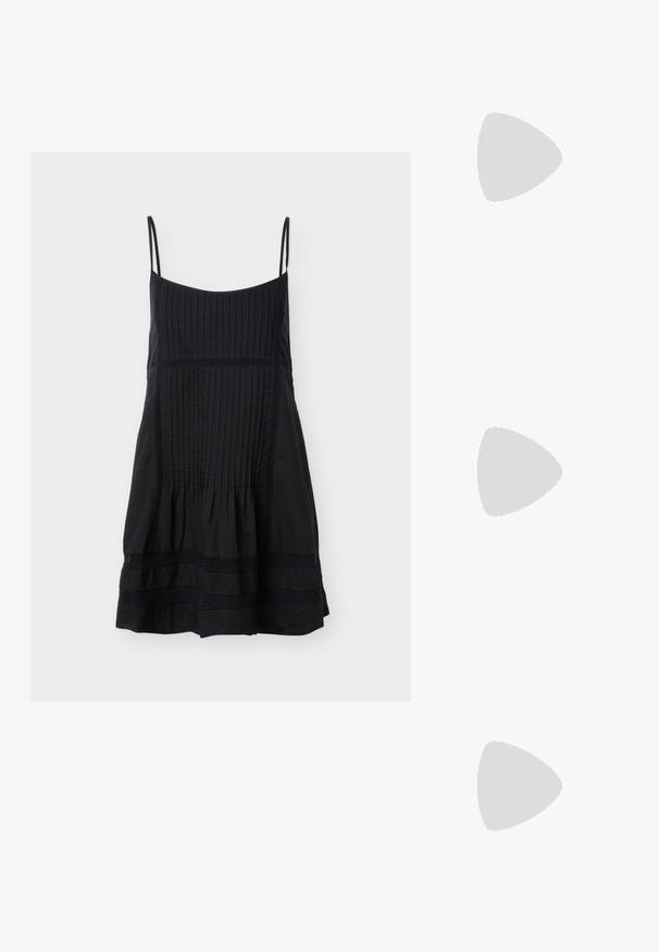 Zwarte mouwloze jurk met smalle bandjes, verticale plooien op de boven- en voorpanelen, en horizontale kanten banden nabij de zoom.; Zwarte gepatineerde ballerina's met een strikaccent, lage blokhak en ronde neus, gedragen met een lange zwarte rok op een houten vloer.; Zwarte handtas met krokodillenstructuur, geplooide bovenrand, samengevoerde handgreep en koordtassels aan elke kant tegen een witte achtergrond.; Zwarte leren riem met een ronde zilveren gesp, een gladde textuur en een strak ontwerp. De band is verstelbaar en heeft een spitse punt.