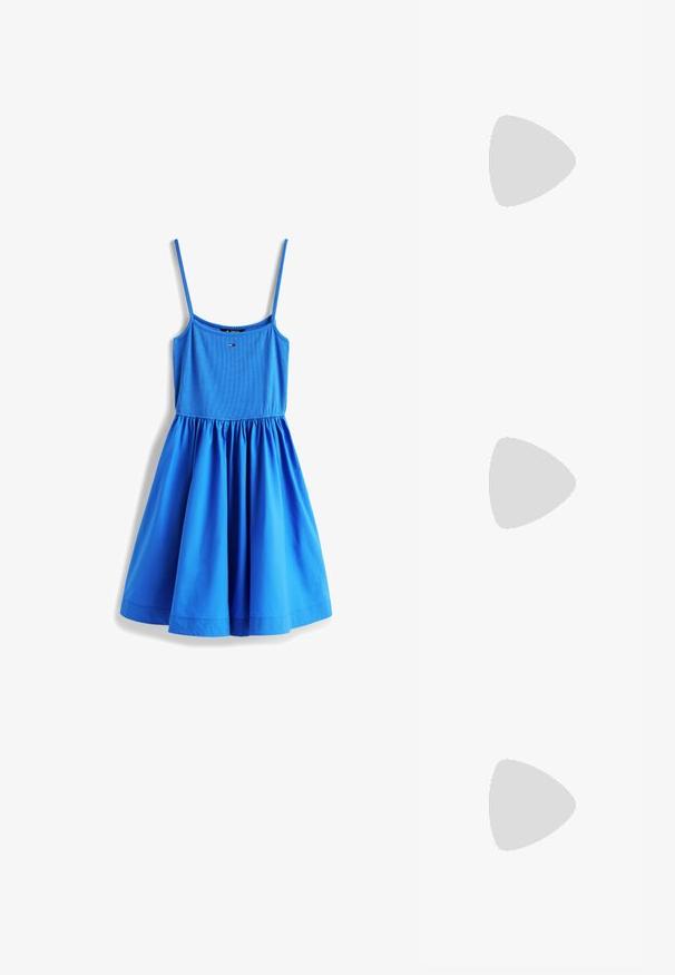 Robe bleue sans manches avec fines bretelles, corsage ajusté, taille froncée et jupe évasée, avec un petit logo au centre de la poitrine.; Chaussure à talon haute en cuir blanc avec un bout pointu et un talon fin, légèrement incliné. Texture lisse avec un design minimaliste et une semelle beige.; Sac à épaule en cuir verni noir avec une bandoulière incurvée, fermeture éclair et un patch rectangulaire avec un logo en rouge, blanc et bleu.; Boucles d’oreilles créoles en métal argenté avec une surface lisse légèrement incurvée et des fermoirs à clapet sur un fond blanc uni.