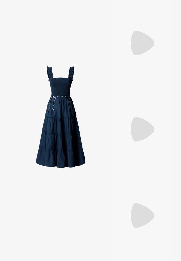 Robe bleu marine sans manches avec bretelles à volants, corsage smocké, jupe à étages et ceinture tressée blanche et bleu marine à la taille.; Bottes de cow-boy en cuir tan avec un bout pointu, des motifs en spirale brodés sur la tige, et un talon bloc empilé. Équipées d'une languette pour un enfilage facile.; Sac fourre-tout en daim marron avec une texture douce, grande ouverture et longues sangles. Présente un design simple avec des coutures visibles et sans matériel.; Ceinture en cuir marron avec une boucle en laiton ronde, présentant une texture lisse et des coutures contrastées le long des bords.