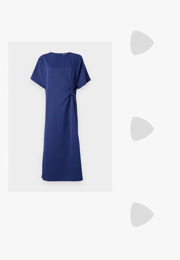 Robe bleu marine à manches courtes, décolleté rond et détail de nœud sur le côté. Fabriquée dans un tissu lisse, elle présente une coupe droite et une longueur jusqu'aux genoux.; Sandale à talon haut en cuir verni noir avec double bride de cheville et boucles dorées, bout ouvert, et talon effilé sur fond neutre.; Sac à main en cuir noir avec un haut froncé, une courte poignée et une bandoulière amovible. Présente un accent logo en or et une texture lisse.; Boucles d'oreilles pendantes en argent avec des cristaux clairs rectangulaires et ronds alignés verticalement, sécurisées par des fermoirs à levier.