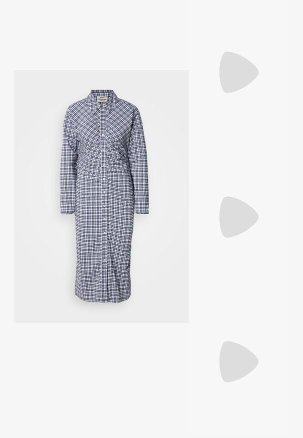 Langarm, knoopsluiting shirtjurk in blauw en wit geruit. Heeft een taillering en een rechte snit, gemaakt van lichtgewicht stof.; Zwarte leren enkellaars met een ronde neus, een gladde textuur en een chunky hak, met een strak schacht en subtiele stiksels.; Zwarte leren shopper met twee schouderbanden en een klein goudkleurig logo onderaan in het midden, afgebeeld tegen een effen achtergrond.; Zilveren creolen met een gepolijste afwerking en DKNY-branding, weergegeven tegen een effen witte achtergrond.