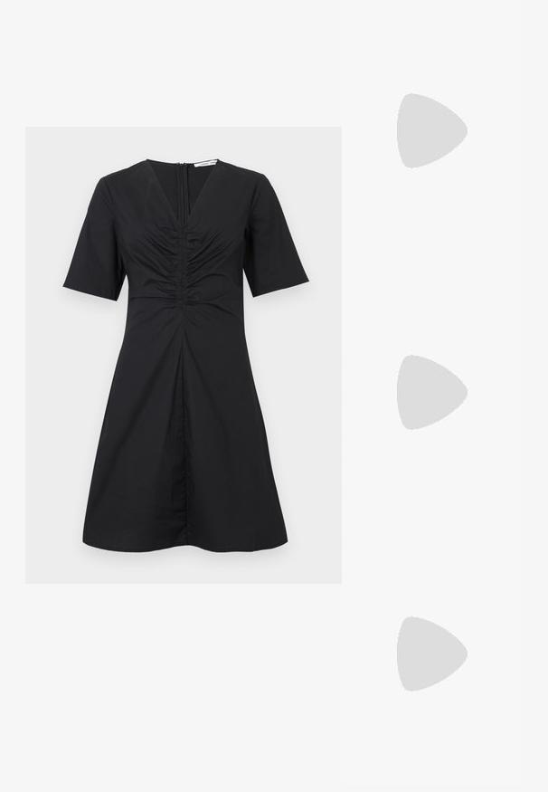 Robe courte noire à manches courtes avec un col en V, un devant froncé et une fermeture éclair au dos ; longueur au genou avec un corsage ajusté et une jupe évasée.; Chaussure Mary Jane en cuir rouge avec motifs perforés et boucle argentée, présentée en suspension au-dessus d'une surface beige texturée.; Sac à main texturé noir avec poignée courte enveloppée d'une écharpe bleue à motifs, bandoulière détachable bleue et blanche réglable posée devant.; Collier chaîne en argent avec pendentif fleur à cinq pétales poli et petite étiquette rectangulaire de marque près du fermoir.