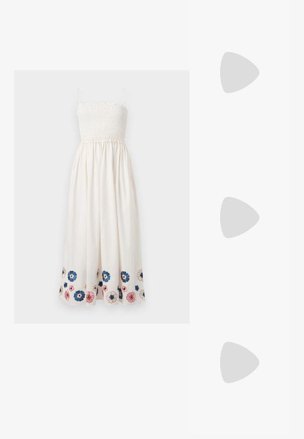 Robe blanche sans manches avec corsage smocké et broderie florale en bleu, rose et beige le long de l'ourlet.; Loeffler Randall LARA STRAPPY - Sandales tongs - timber; Sac cabas en paille beige tissée avec des poignées tressées vertes et noires et un patch rectangulaire coloré à l'avant.; Boucles d'oreilles asymétriques avec pendentifs en coquillages, clous dorés avec dessus en perle et petites pierres précieuses transparentes incrustées sur chaque coquillage.
