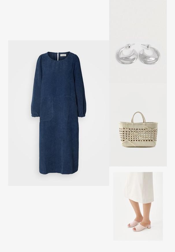 Vestido de pana azul marino con mangas largas abullonadas, escote redondo, dos bolsillos delanteros y una abertura en la parte posterior en forma de llave. Tejido suave y texturizado.; Piernas con falda midi color crema y mules de tacón ancho color rosa pálido con punta abierta sobre fondo blanco.; Bolso tote tejido en beige con centro de celosía abierta y múltiples lazos atados, con asas cortas trenzadas.; Un par de pendientes de aro en forma de media luna pulidos en plata, con respaldos de plástico transparente, sobre una superficie blanca.