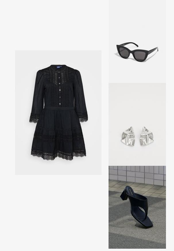 Vestido negro de tela ligera, con un frente abotonado, mangas largas, detalles de encaje y una falda escalonada con un dobladillo con formas onduladas.; Sandalia negra de tacón con puntera cuadrada y tiras anchas, colocada sobre asfalto gris cerca de una pared con azulejos.; Gafas de sol negras en forma de ojo de gato con un acabado mate, que presentan lentes ahumados grises, ángulos pronunciados y brazos laterales elegantes. Nombre de la marca visible en el interior del brazo.; Pendientes de metal plateado con un diseño ondulado y escultórico, que presentan un acabado pulido y formas irregulares, destacando una estética contemporánea.