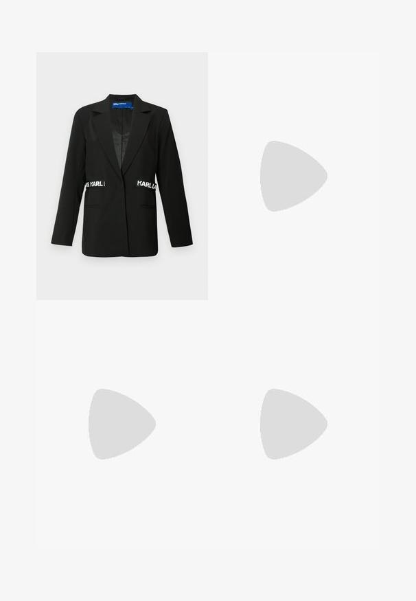 Zwarte blazer met een slim-fit ontwerp, enkele knoopsluiting, twee voorzakken en "Karl" logo-accenten aan de zijkanten. Soepele stoftextuur.; Witte mouwloze crop top met hoge nek en het "Karl Lagerfeld Jeans" logo op de onderzijde rechts voor.; Zwarte geribbelde midi-rok met een witte gebrandmerkte elastische tailleband. De stof heeft een gladde textuur en een figuurvormend ontwerp.; Zwarte lakleren slingback hakken met puntige neus en KARL LAGERFELD merkafwerking, gedragen op voeten staand op een houten vloer.