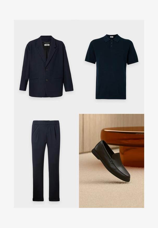 Dunkelblazer in Marineblau mit zwei vorderen Knöpfen, Reverskragen und zwei Paspeltaschen, mit dem Label Drykorn am inneren Kragen.; Marineblaue Polohemden mit kurzen Ärmeln, aus strukturiertem Stoff, mit einer Dreiknopf-Leiste sowie gestricktem Kragen und Bündchen.; Dunkelblaue Hose aus weichem Stoff, mit elastischem Bund, Falten an der Vorderseite und umgeschlagenen Säumen. Glatte Textur, minimalistisches Design.; Schwarzer Leder-Slipper auf beigefarbenem Teppich neben einem gebogenen bernsteinfarbenen Glastisch in einem neutral gestalteten Raum.