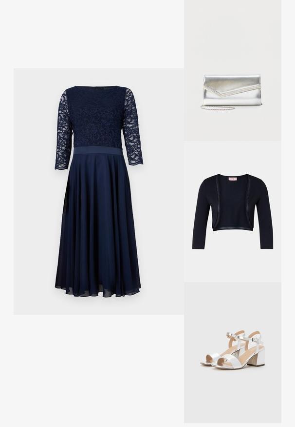 Marineblå kort cardigan med en blød, glat tekstur, der har lange ærmer og satin detaljer langs den åbne front.; Mørkeblå kjole med blonde overdel, trekvart ærmer og en flydende chiffon nederdel. Glat tekstur med en tætsiddende talje.; Sølv høje hæle sandaler med åbne tæer, der har to brede stropper og en rund blokhæl. Glat tekstur med metallisk finish.; Skinnende sølv clutch taske med kuvertlåg og dekorativ kant, lille sølvkæde, på ensartet lys baggrund.