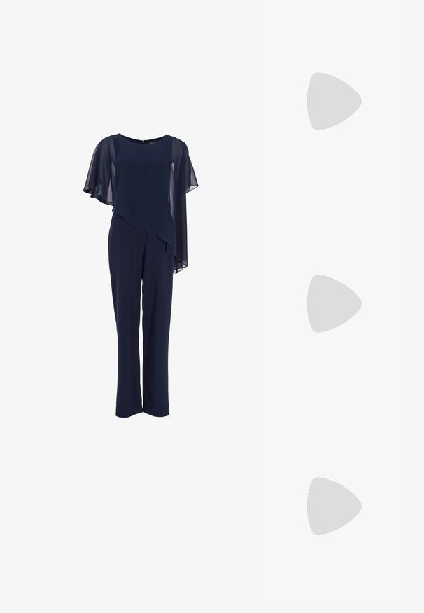 Marineblauw jumpsuit met asymmetrische doorschijnende cape die over één schouder valt, ronde halslijn en rechte pijpen.; Zwarte hoge hakken sandalen met een open teen, dunne banden en een enkelsluiting. Gladde leren textuur met een puntige neus.; Blauwe met kristallen bezette handtas met zwarte band, voorzien van een verticale zilveren strass-streep in het midden en een strikvormige versiering op de voorflap.; Lange zilveren oorbellen met een scala aan heldere, facetteerde kristallen in een waterval van strengen met variërende lengtes en vormen.