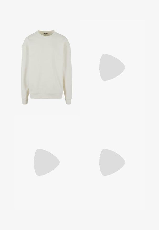 Svetlosivý krémový crewneck sveter vyrobený z mäkkej zmesi bavlny. Obsahuje rebrované manžety a lem, s klesajúcimi ramennými švami pre voľný strih.; Jednoduché biele tričko s krátkym rukávom a okrúhlym výstrihom, s malou obdĺžnikovou nášivkou „Rebel“ na pravom dolnom okraji.; Béžové nohavice s rovnými nohavicami zobrazené zozadu, s opaskovými pútkami a dvoma pútkovými vreckami na páse.; Biely kožený tenisky s čiernymi koženými doplnkami, zaoblenou špičkou a podrážkou z gumy. Obsahuje perforované detaily a výrazné logo značky.