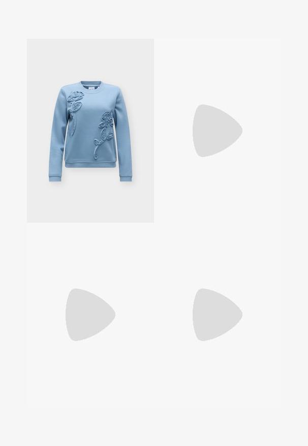 Lyseblå langærmet sweatshirt med rund halsudskæring og forhøjet blomsterbroderi foran med to roser og blade.; Mørkeblå fløjlbukser med høj talje, bred benåbning, to baglommer og knappelukning foran. Blød tekstur med en glat overflade.; Ben iført mørke ribbede leggings kombineret med sorte balletsko med små sløjfedetaljer på hvid baggrund.; Bordeaux håndtaske lavet af glansfuldt materiale, rektangulær form, med to skulderremme og subtile buede detaljer på forsiden.