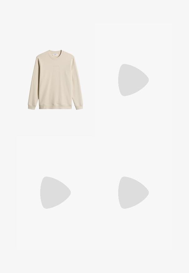 Beige longsleeve trui met ronde hals, geribbelde manchetten en zoom, met subtiele tekstbranding op de borst en een stoffen label aan de binnenkant van de kraag.; Effen wit T-shirt met korte mouwen en een ronde hals, plat liggend op een lichtgrijze achtergrond met een klein merkje aan de binnenkant van de halslijn.; Lichtblauwe spijkerbroek met een rechte snit, voorzien van vijf zakken, een ritsluiting en subtiele vervaging op de stof. Metaal knoopsluiting.; Witte leren lage sneaker met veters, zwevend boven een beige vloerkleed met textuur, vlakbij een ronde houten salontafel met boeken.