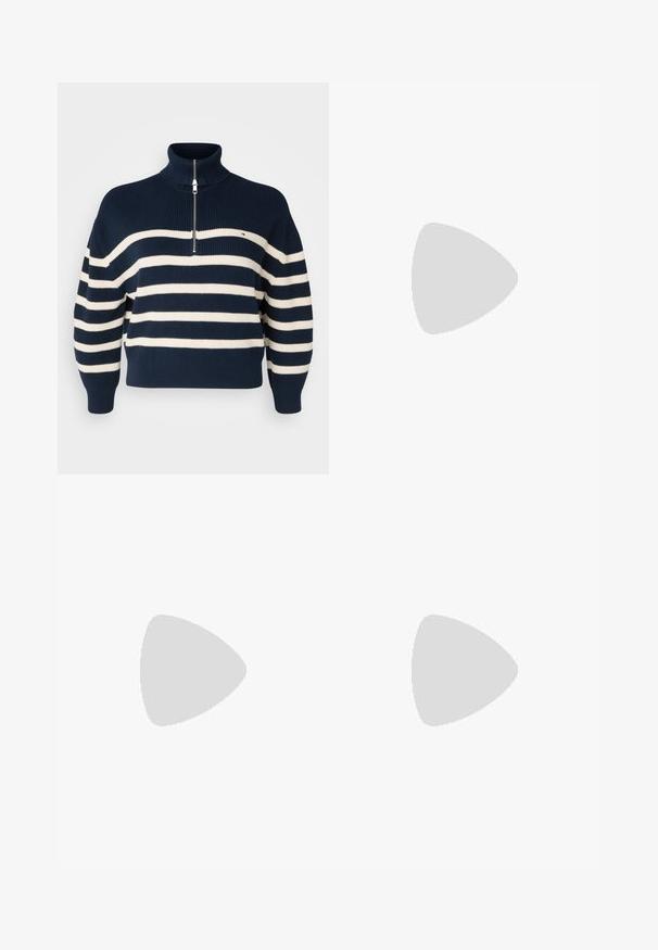 Marineblauwe en witte gestreepte gebreide trui met een hoge kraag, een halve rits aan de voorkant en geribbelde manchetten en onderrand. Bevat een klein logo op de borst.; Donkerblauwe spijkerbroek met een rechte snit, vijf-pocket ontwerp, zichtbare stiksels en een metalen knoopsluiting bij de tailleband.; Ben met witte sokken en zwarte Adidas Gazelle sneakers met witte strepen en dikke bruine zolen op een grijs tapijt.; Zilveren oorbellen in de vorm van een gladde, glanzende ring. Circulaire vorm, voorzien van een veilige sluiting. Eenvoudig en elegant ontwerp.
