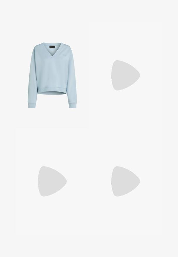 Lyseblå cropped sweatshirt lavet af blødt stof med V-udskæring, lange ærmer og et subtilt broderet logo foran.; Grå kortærmet skjorte lavet af letvægtsstof, med krave, knaplukning foran, en enkelt brystlomme og en afslappet pasform.; Denim flared jeans i lys til mørk blå gradient, med høj talje, fem lommer og lys falming på de nederste ben.; Hvid lavtop-sneaker med snørelukning foran, lys beige sål, subtilt syningsdesign på siden og metalisk sølvhælkappe.