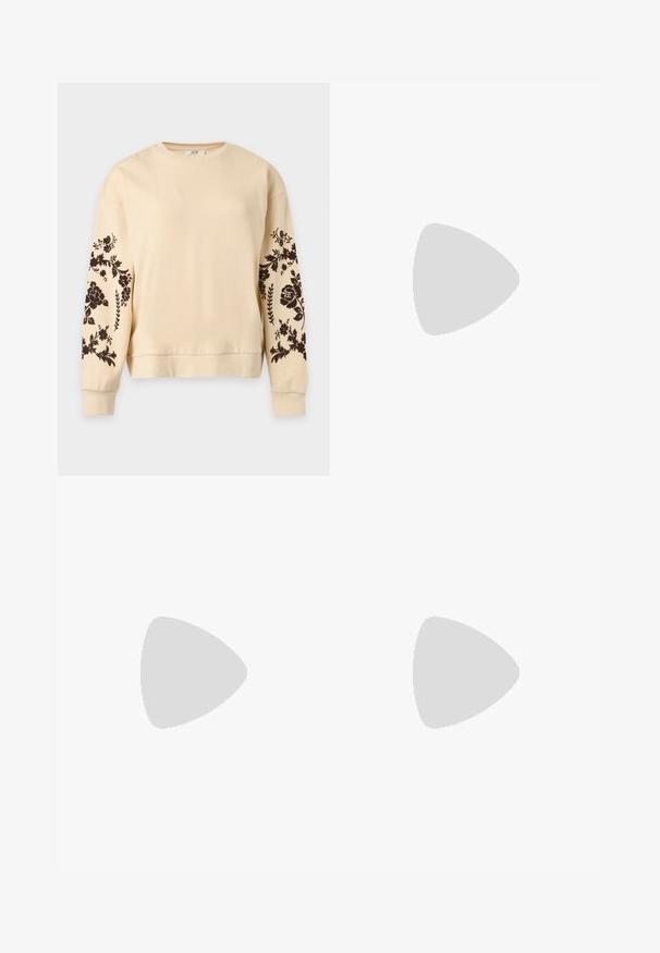 Sweat-shirt beige à manches longues avec motifs floraux noirs sur les deux manches et poignets et ourlet côtelés.; Jean en denim bleu clair à jambes larges, fermeture par bouton et zip, poches latérales et cordons ajustables aux chevilles.; Ballerine en cuir verni marron avec un bout carré et une lanière ornée d'une petite boucle dorée. Texture lisse, talon bas et design minimaliste.; Petit sac à main noir brillant avec deux longues anses et des détails à cordon sur les côtés sur un fond clair uni.