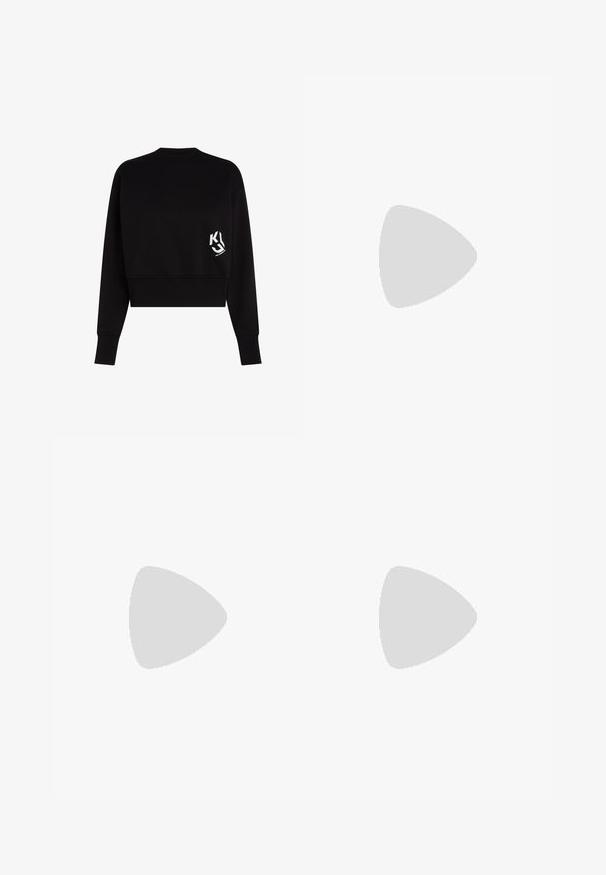 Čierny skrátený sveter vyrobený z mäkkého materiálu, s okrúhlym výstrihom a dlhými rukávmi. Na ľavej strane hrude sa nachádza biele logo.; Tmavomodré denim jeans so štíhlym strihom. Medzi vlastnosti patrí pás na gombíkový zapínanie, päť vreciek a minimálne švy.; Čierny dámsky mule topánka na vysokom podpätku s otvorenou špičkou a vyrezanými stranami, zobrazený vonku na drevených latkách s rozmazaným zeleným lístím v pozadí.; Čierna obdĺžniková kabelka s reťazovým remienkom a veľkým čiernym kovovým logom "Karl" na prednom prepínacom dne.