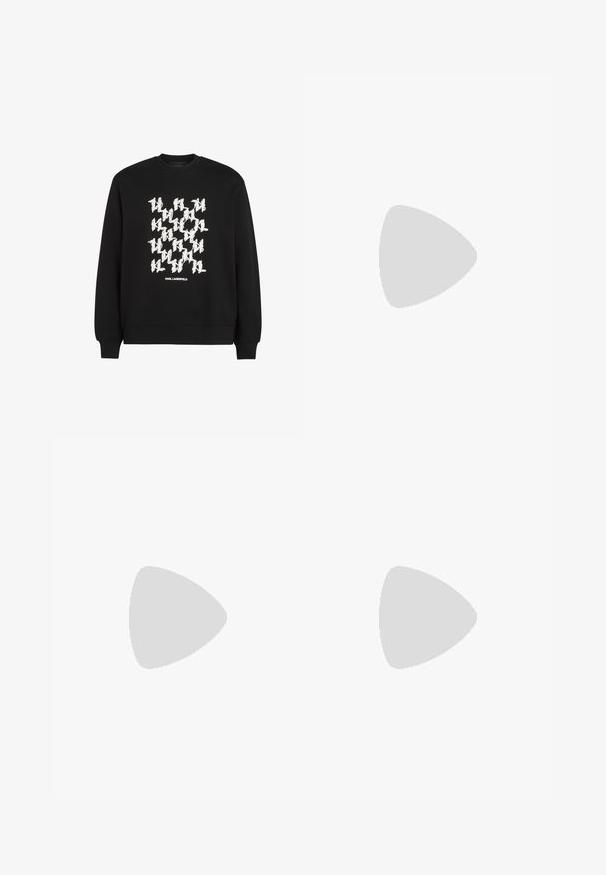 Sudadera negra con un atrevido patrón gráfico en blanco y el texto "KARL LAGERFELD" en la parte inferior. Fabricada en suave tela de algodón.; Camiseta de algodón negra con un gráfico blanco de un personaje estilizado que lleva gafas de sol grandes, con el texto "KARL LAGERFELD" debajo de la imagen.; Jeans de mezclilla gris oscuro con corte recto, que cuentan con cinco bolsillos, cierre de botón y detalles sutiles de descolorido a lo largo de las piernas.; Piernas con calcetines blancos acanalados y zapatillas blancas Karl Lagerfeld, de pie sobre un suelo de parquet de madera clara.
