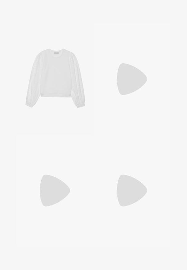 Hvid sweatshirt med en ensfarvet krop og gennemsigtige puf ærmer med prikket mønster. Ribstrikkede manchetter og kant samt rund halsudskæring.; Sort nederdel lavet af blødt stof, med en samlede talje, knælangt design og små sløjfer med perler med mellemrum.; Ben iført mørke ribbede leggings kombineret med sorte balletsko med små sløjfedetaljer på hvid baggrund.; Sort læderhåndtaske med en buet form, struktureret overflade, forreste syninger og et logo i guldfarve. Har en enkelt justerbar rem.