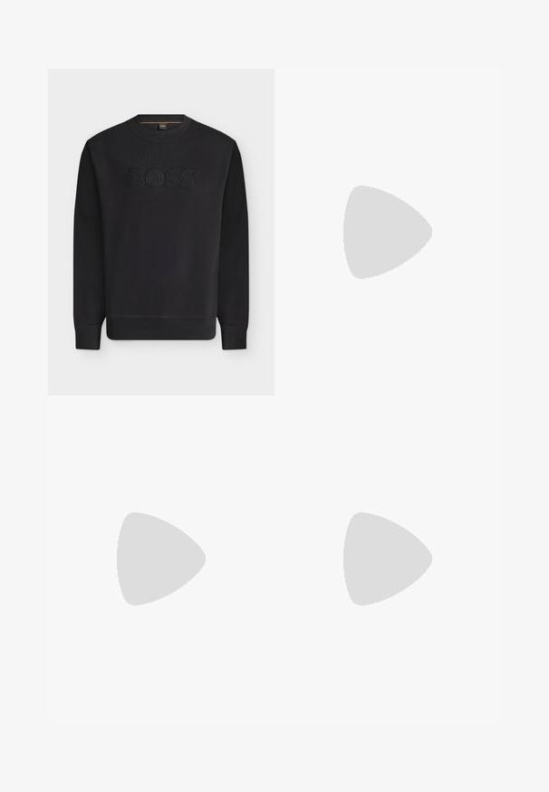 Sweat-shirt noir à manches longues col rond avec poignets et ourlet côtelés, avec texte noir en relief "BOSS" au centre devant.; T-shirt noir à manches courtes avec col ras du cou, portant une petite étiquette verte « BOSS » à l'intérieur du col.; Pantalon beige ajusté avec fermeture à boutons et fermeture éclair, passants pour ceinture et plis plats à l'avant, présenté à plat sur un fond blanc.; Mocassin en cuir noir à talon bas flottant au-dessus d'un sol moquetté beige près d'une table ronde marron.