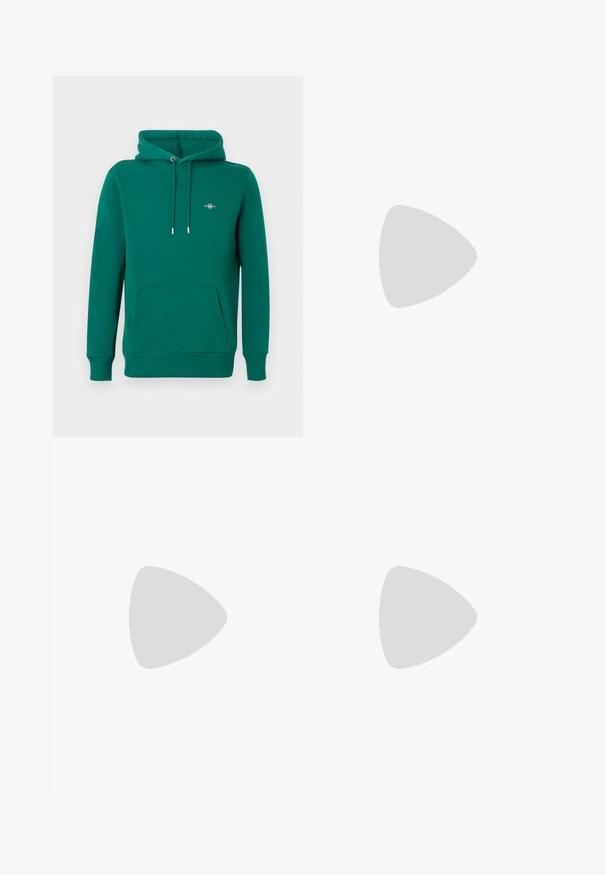 Sweat à capuche vert avec poche avant, capuche à cordon, poignets côtelés et logo brodé sur la poitrine. Fabriqué en matériau doux et confortable.; T-shirt blanc à manches courtes avec col rond et poche poitrine avec un détail de fines rayures rouges et noires.; Jean bleu clair à coupe droite avec zones délavées, cinq poches, fermeture par bouton et étiquette Calvin Klein sur la poche avant droite.; Baskets basses blanches avec un design à lacets et une languette marron au talon sur un fond clair uni.