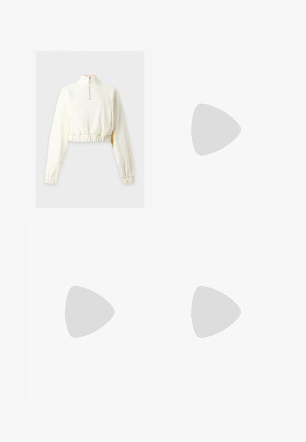 Langærmet cremefarvet cropped sweatshirt med høj krave og halv lynlås, med elastisk talje og manchetter.; Grå sweatpants med elastisk talje, snor detaljer og et lille hvidt Nike-logo på venstre lår. Blødt stof, løs pasform.; Sorte lædersneakers med perforeret tåboks, flade snørebånd og gummisål. Har et lille logo på siden og tekstureret detaljering.; Sorte rektangulære solbriller med mørkt tonede linser, tyk plastramme og brede stænger. Glat overflade og kantet design.