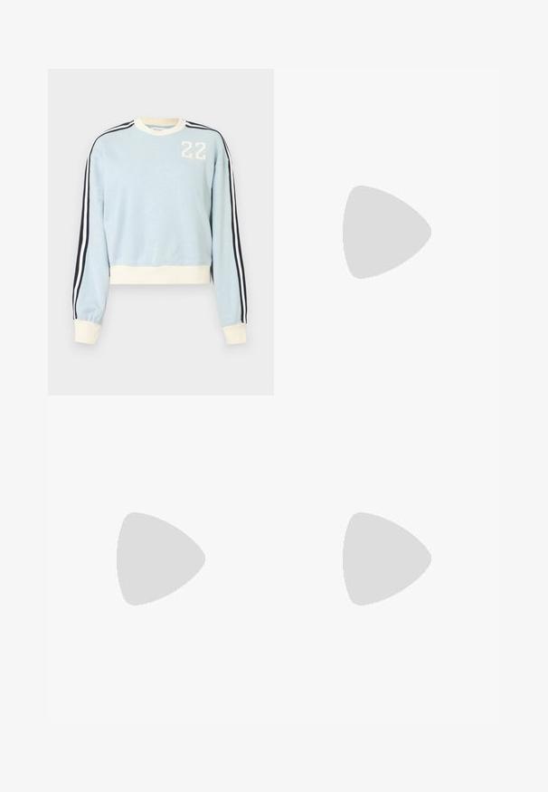 Sweat-shirt bleu clair à manches longues avec poignets et ourlet blancs, rayures noires et blanches sur les manches, et "22" blanc imprimé sur la poitrine.; Top court sans manches bleu marine avec bordure blanche et bretelle réglable derrière le cou sur fond uni.; Pantalon large bleu clair avec taille élastique, tissu lisse et design minimaliste, présenté sur un fond blanc uni.; Baskets Adidas Samba blanches avec des bandes en daim marron, semelle en caoutchouc marron et bout en daim beige, vues du côté extérieur sur un fond uni.