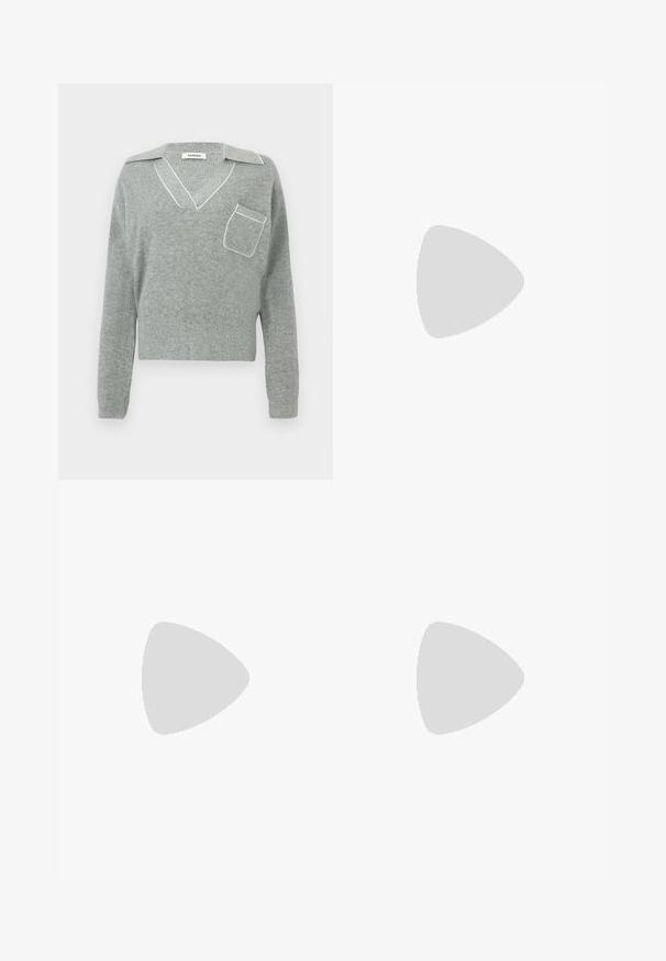Pull en tricot gris avec un col en V et des finitions blanches contrastantes, doté d'une poche avant et de manches longues. Texture légère.; Pantalon gris ajusté avec une coupe droite, un devant plissé et une finition texturée, comprenant des passants de ceinture à la taille.; Chaussure en cuir noire à double boucle monk, équilibrée sur un banc en bois avec un fond d'herbes hautes et vertes.; Sac à main rectangulaire en cuir noir avec deux fines bandoulières sur un fond clair uni.