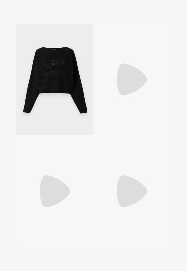 Suéter corto negro de punto con mangas largas, que presenta una textura de tejido abierto y un escote amplio. Ribete acanalado en la parte inferior y en los puños.; Pantalones cortos de vellón negro con cintura elástica y cordón, con un pequeño lazo de strass rosa en la parte inferior de la pierna derecha.; Zapato plano de piel negra con puntera afilada, detalle fruncido alrededor de la abertura y un acento de hebilla plateada en la correa ajustable.; Bolso negro fruncido con asa recogida, apoyado sobre una esfera de piedra texturizada frente a una pared de hormigón beige.